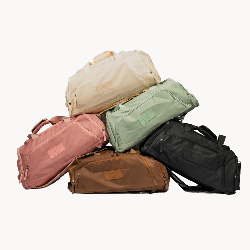 Stack of five colorful duffel bags on a white background