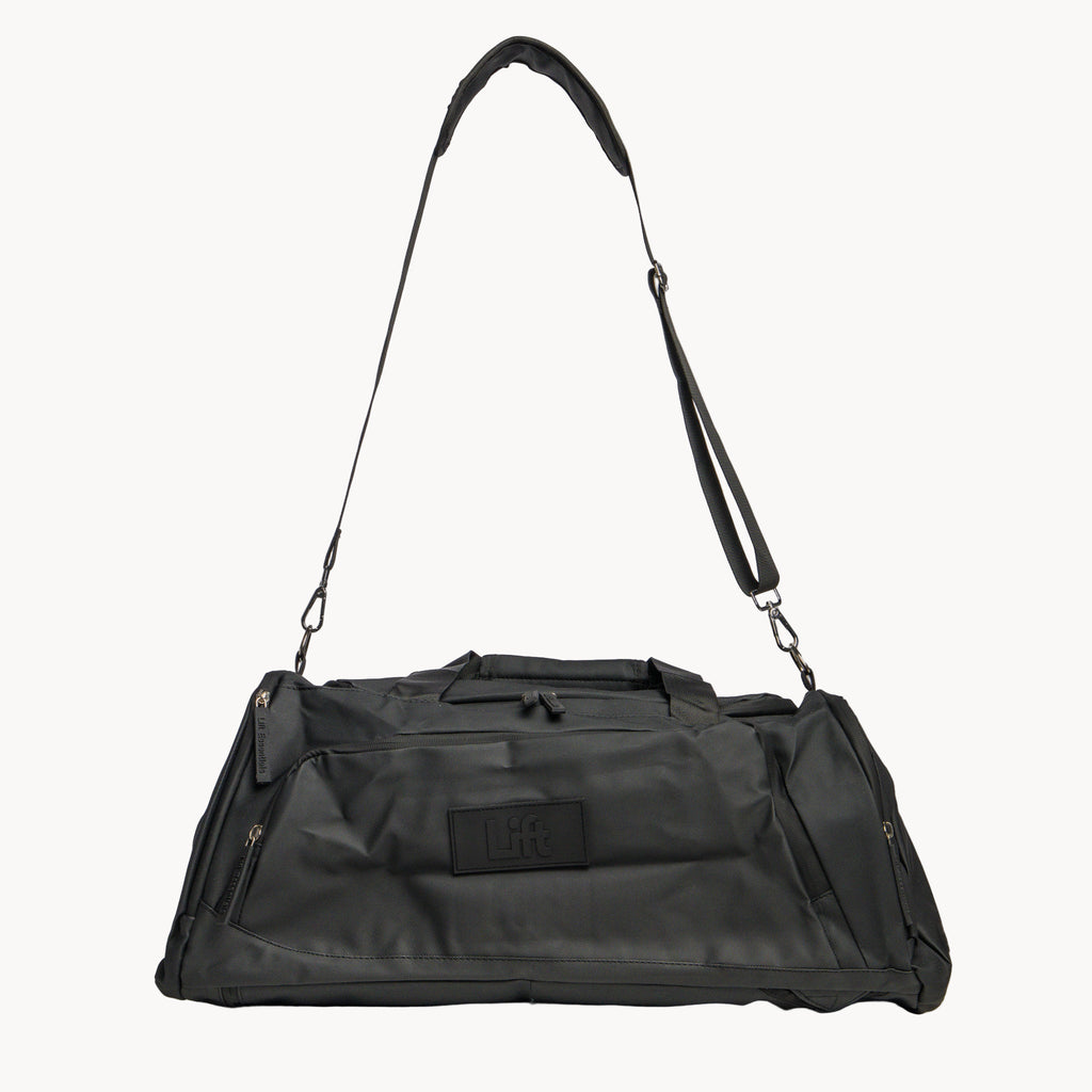 Black duffel bag with shoulder strap on a white background