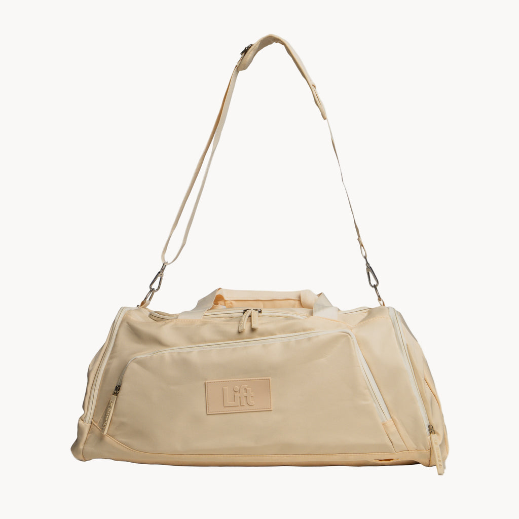 Beige duffel bag with a visible brand logo on a white background